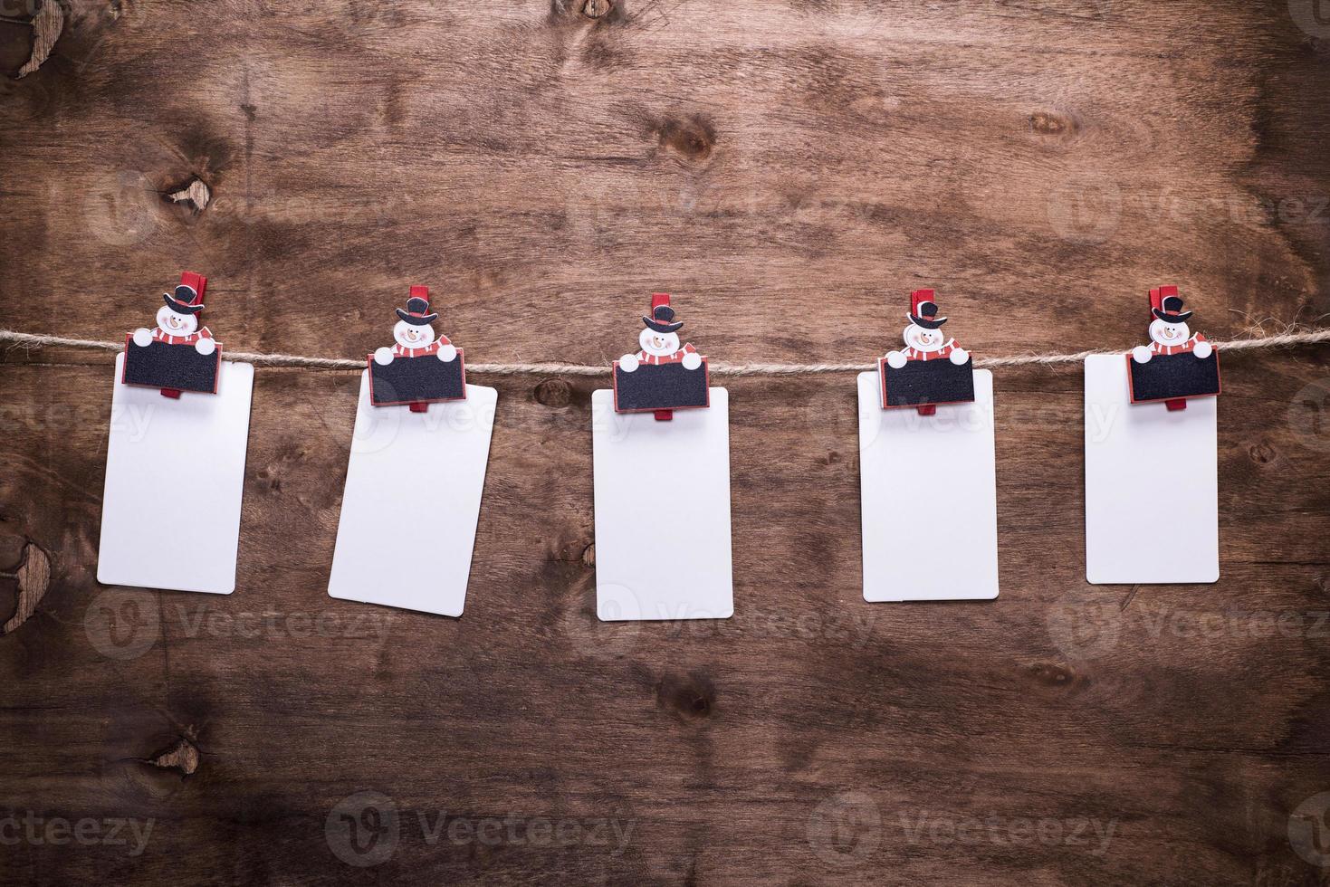 etiquetas de papel colgando de una cuerda enganchadas en pinzas decorativas de navidad foto