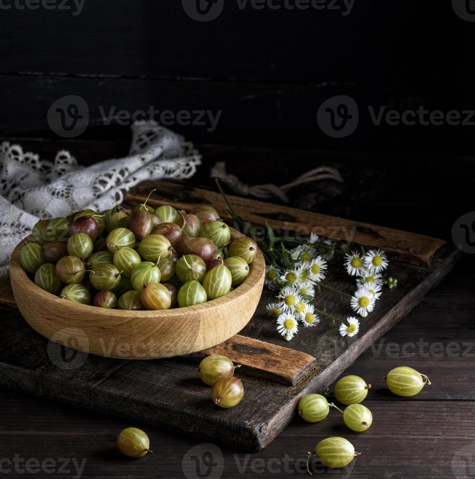 wooden bowl with green gooseberries photo