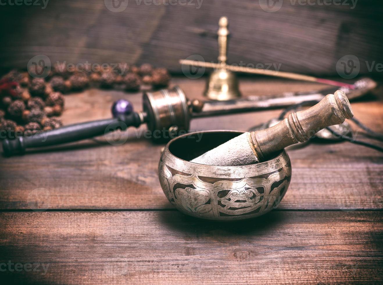 copper singing bowl and a wooden stick photo