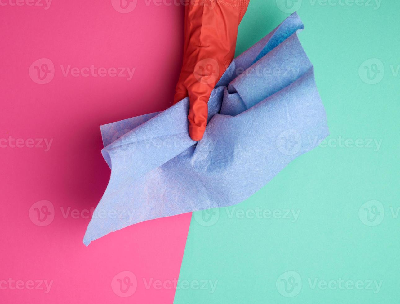 blue viscose rag for cleaning dust in the house in hands with an orange glove photo