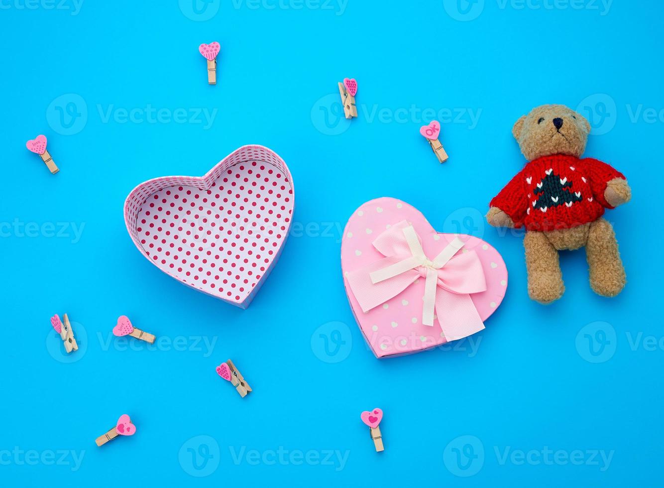 open empty cardboard box in the form of a heart and little brown teddy bear photo