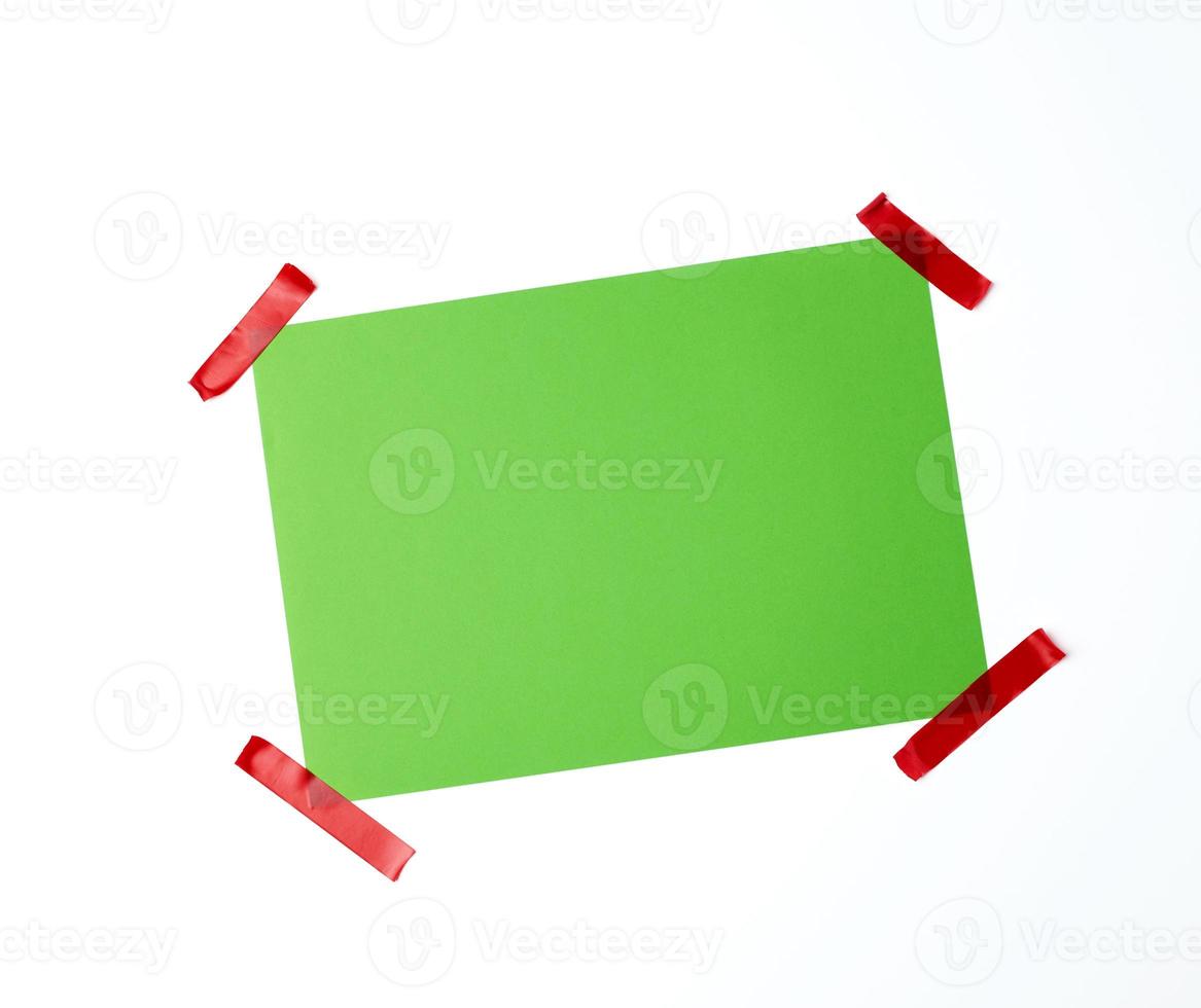 blank green sheet of paper stuck with red sticky tape photo