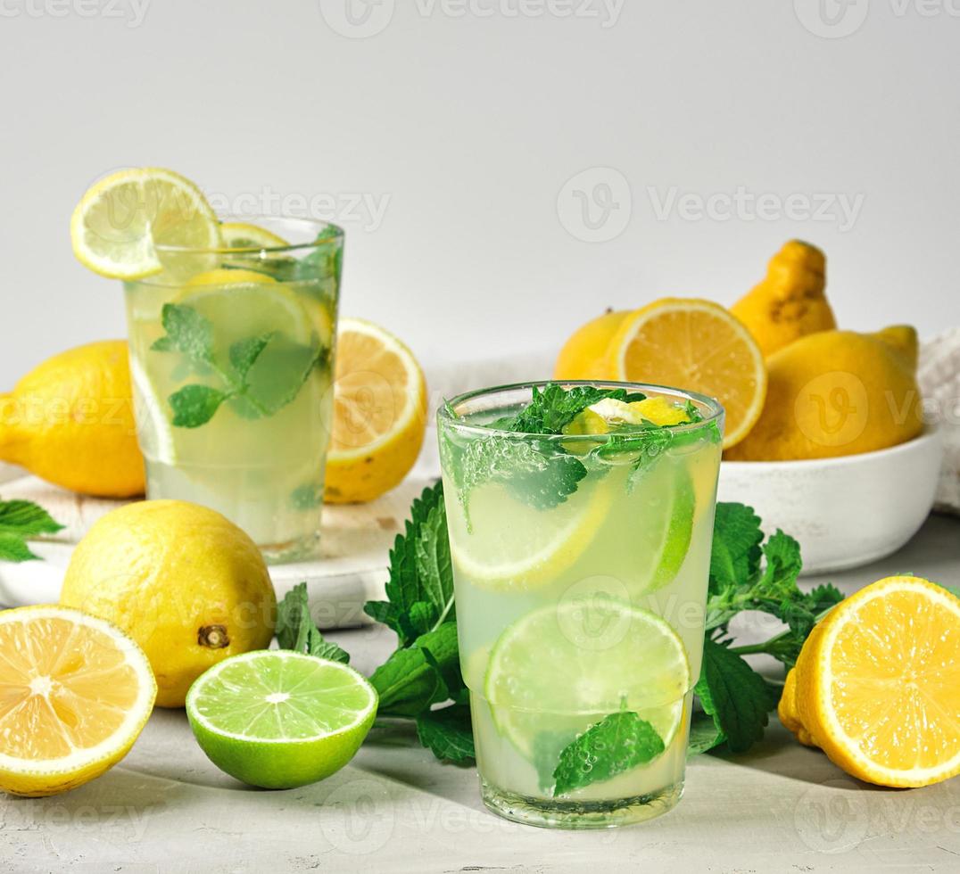 refreshing drink lemonade with lemons, mint leaves, lime in a glass photo