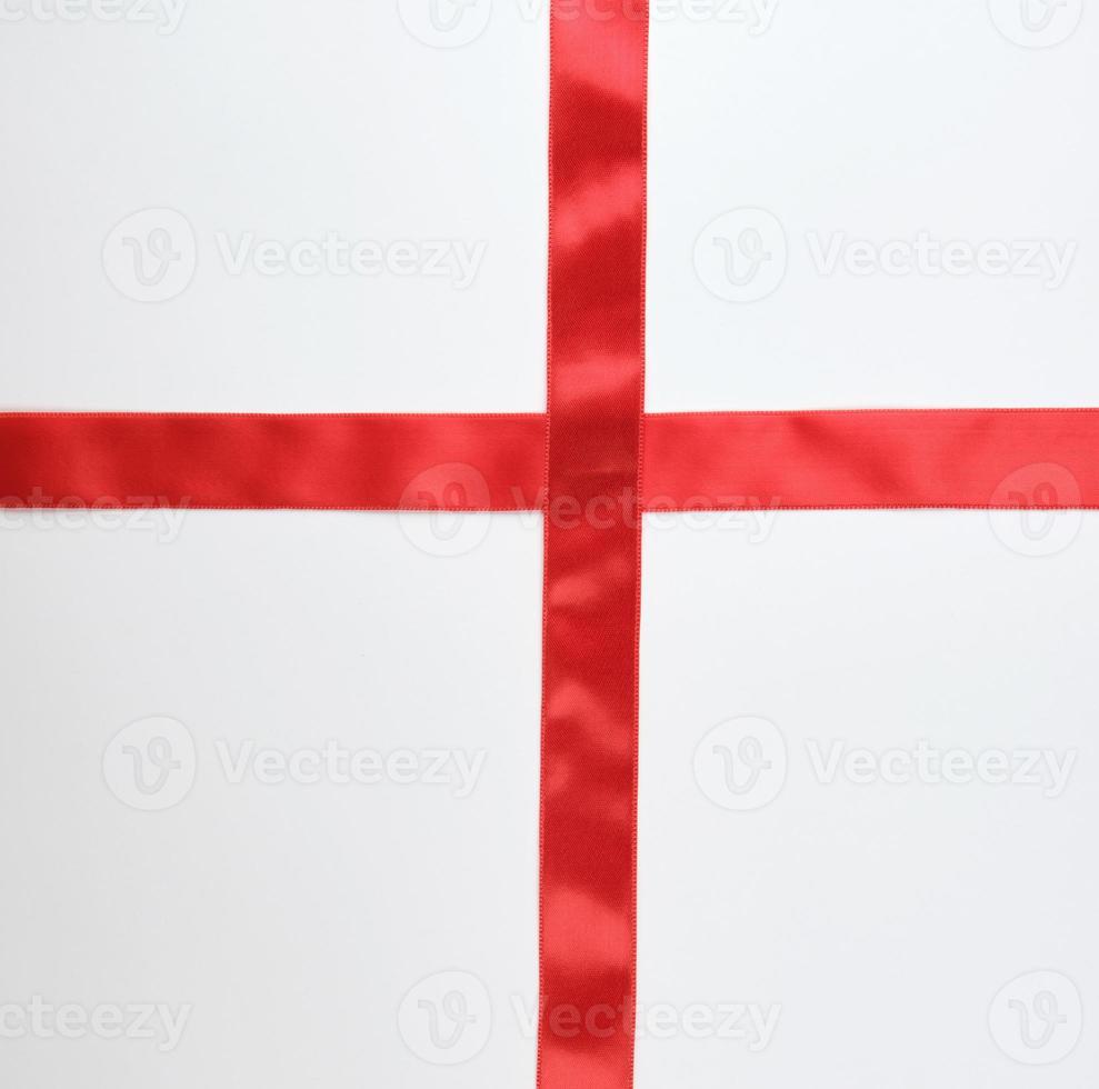 red satin ribbon cross to cross on white background photo