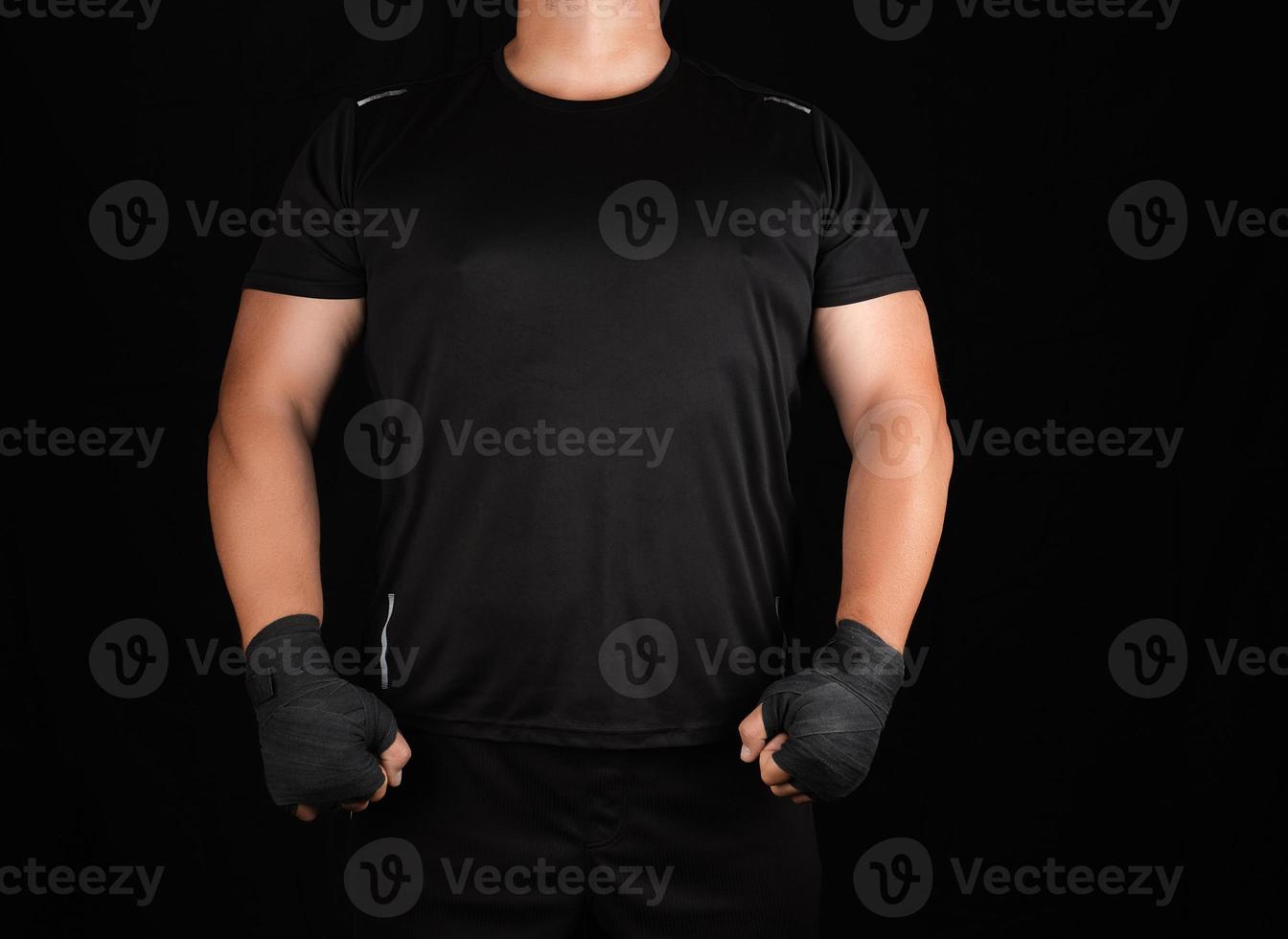 adult athlete in black uniform is standing in a rack with strained muscles photo