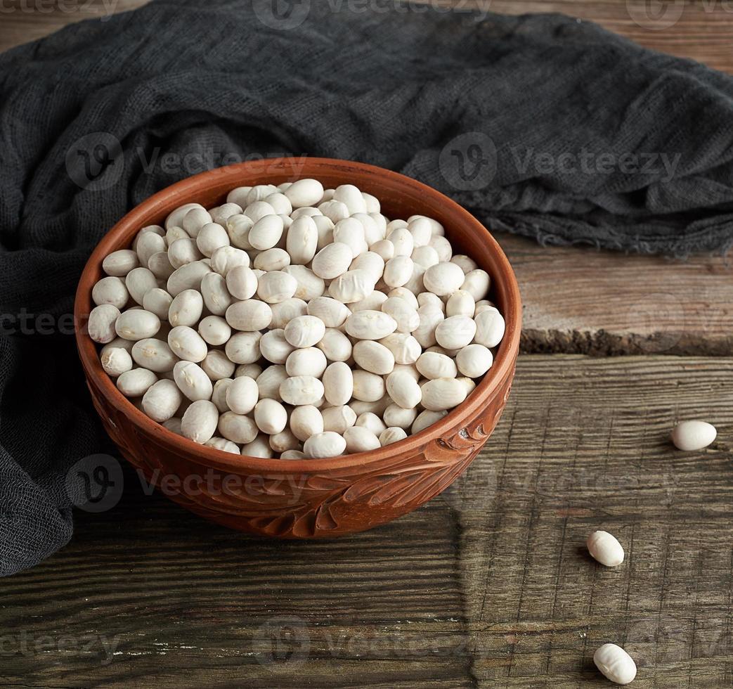 frijoles blancos redondos crudos en un plato sobre una mesa de madera foto