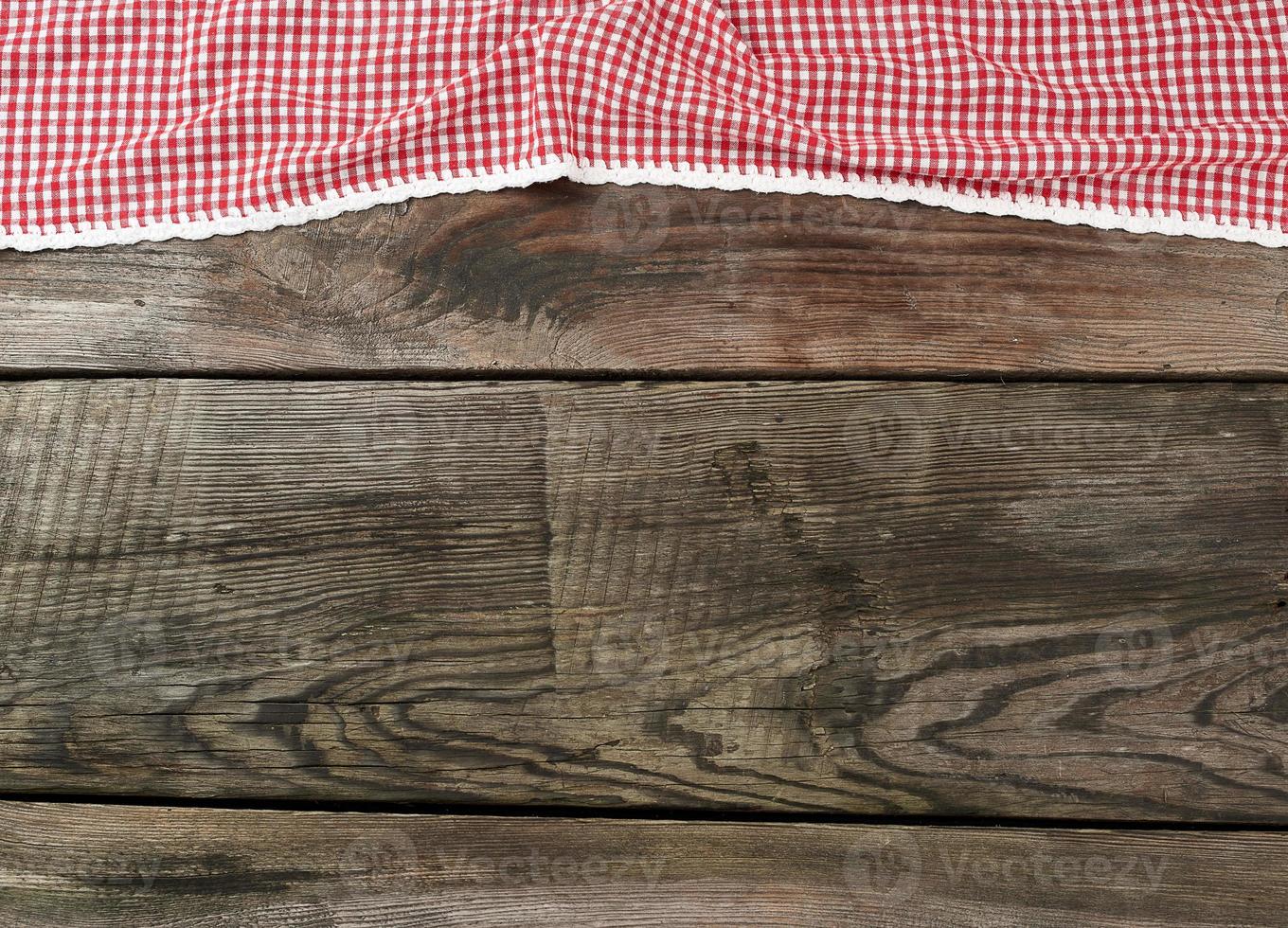 red-white textile kitchen towel on a wooden background from old gray boards photo