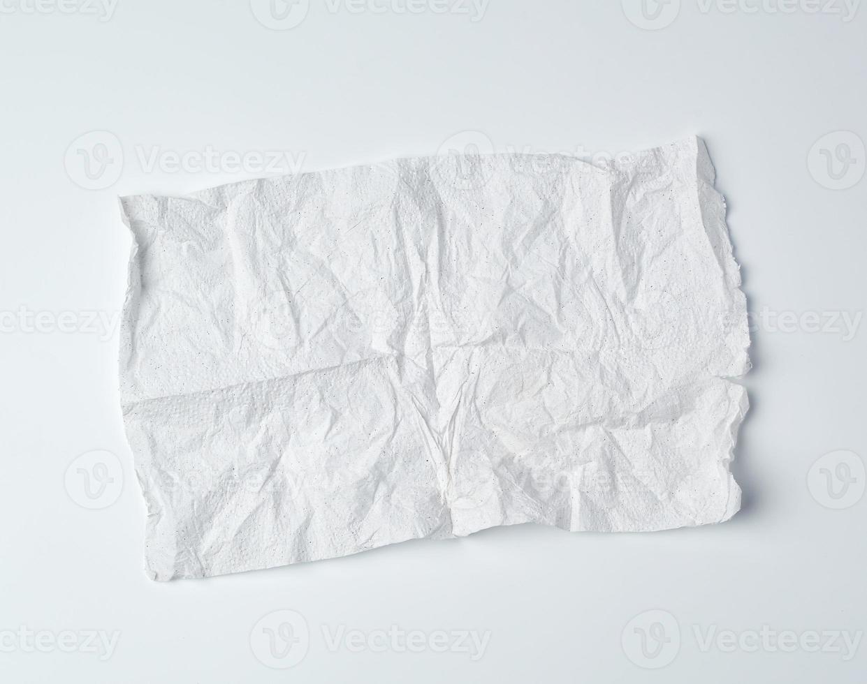 crumpled torn soft white sheet of paper towel with curled corners photo