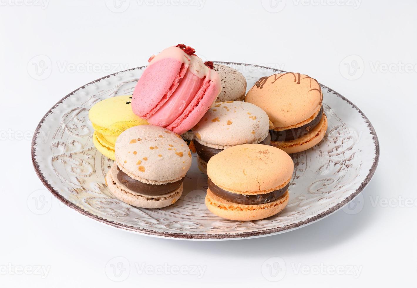 baked almond macarons on a white ceramic plate, white background photo