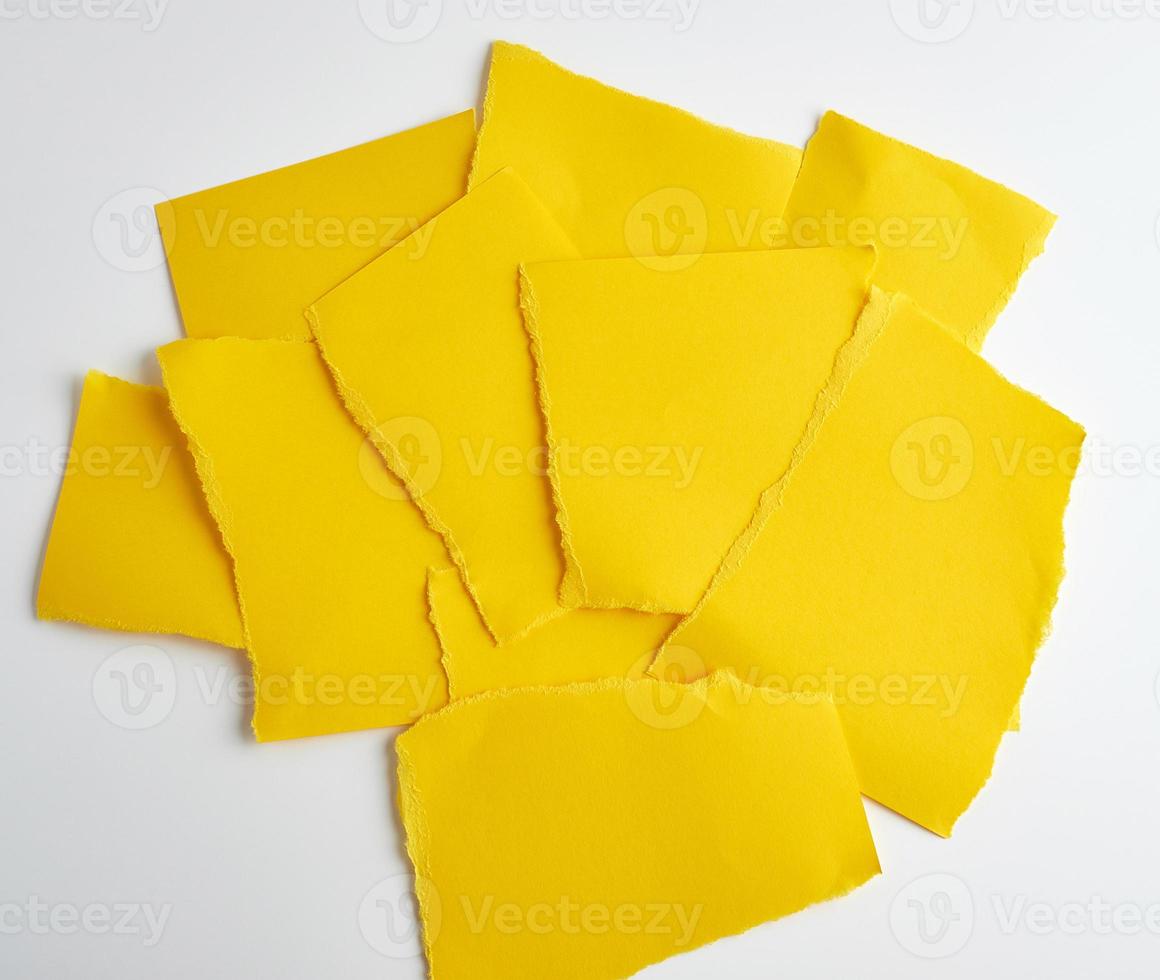 stack of yellow paper torn pieces of paper on a white background photo