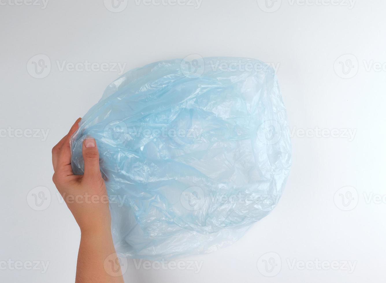 blue plastic garbage bag in female hand photo