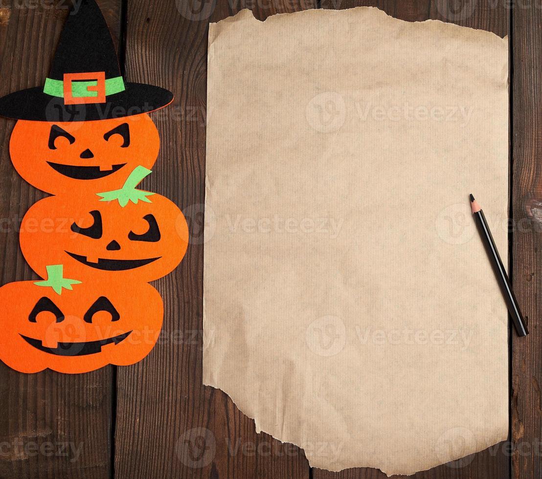 pedazo de papel marrón y figuras de fieltro de calabaza naranja foto