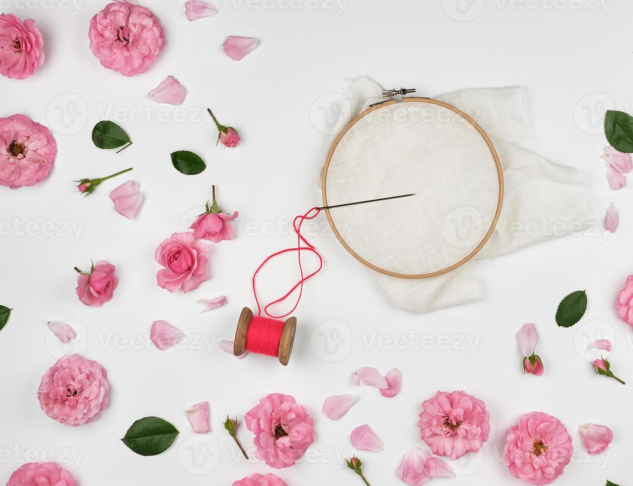 round wooden hoop and a red thread with a needle photo