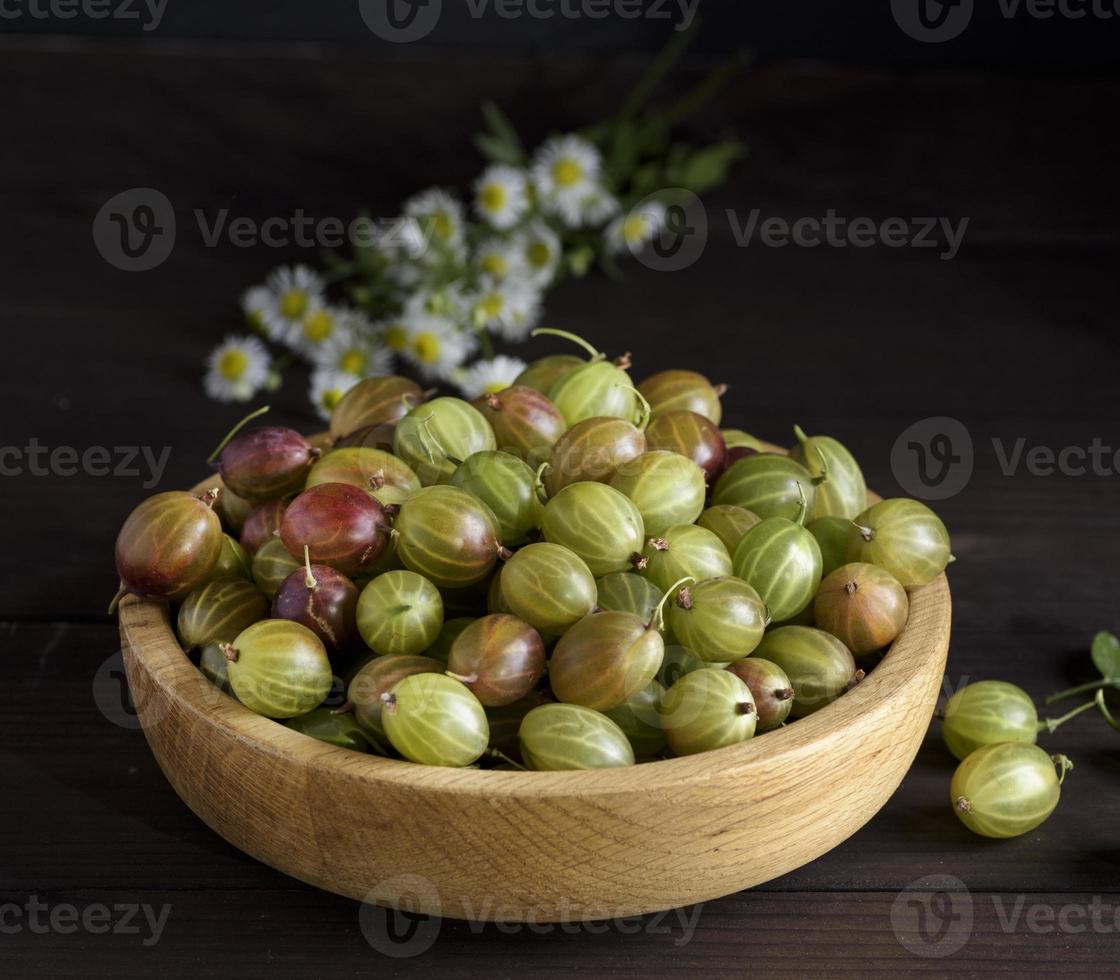 ripe berries of green gooseberry in a wooden bowl photo