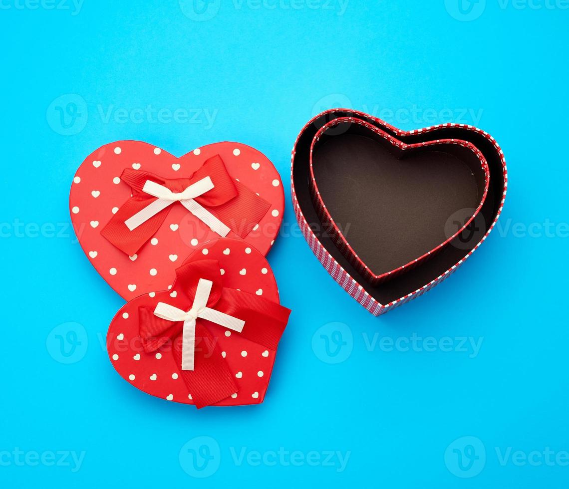 open empty red cardboard box in the form of a heart on a light blue background photo