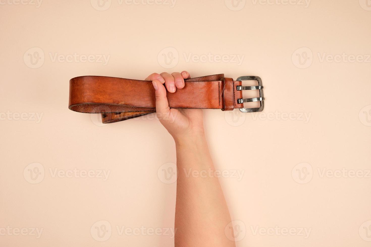 leather brown belt in a female hand photo