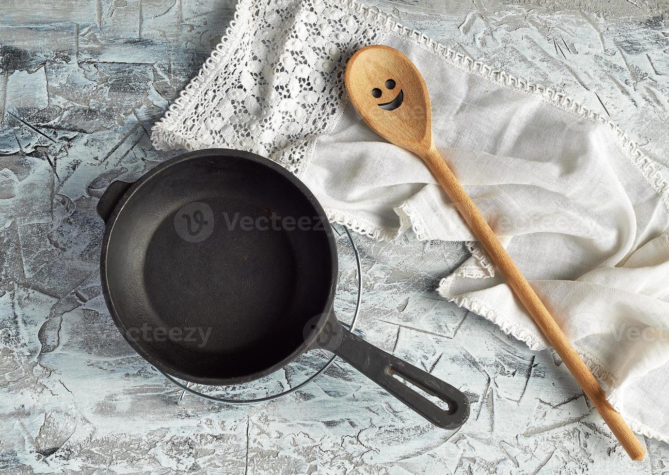 empty black round frying pan with handle and spoon photo