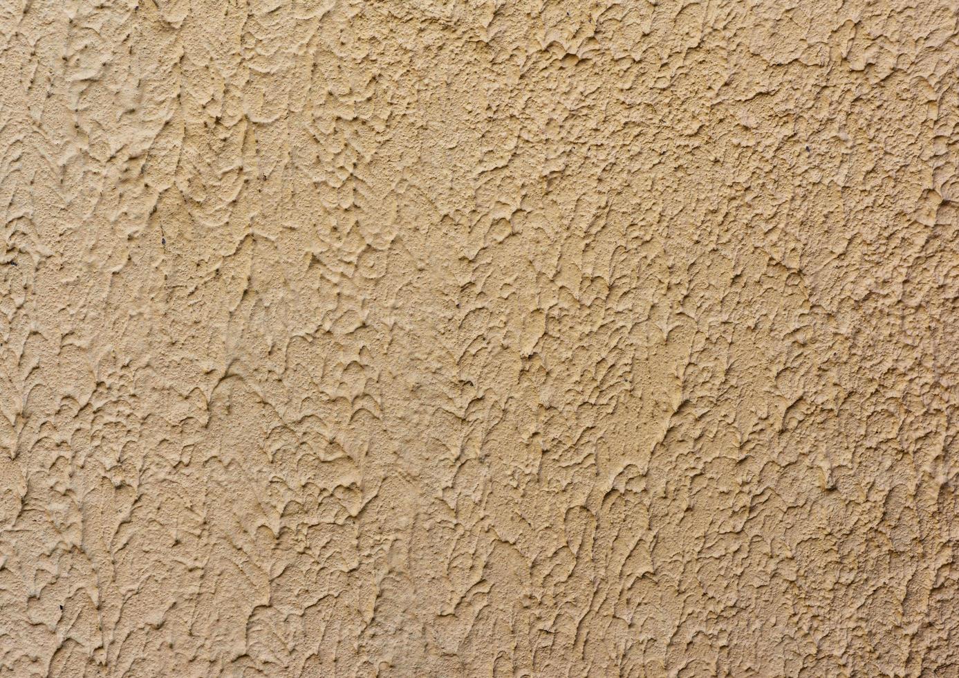 fragment of beige wall with decorative plaster of waves photo