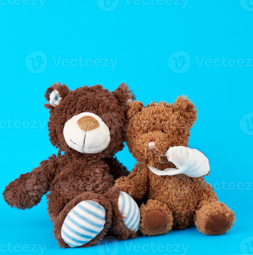 brown teddy bear with rewound white bandage paw photo