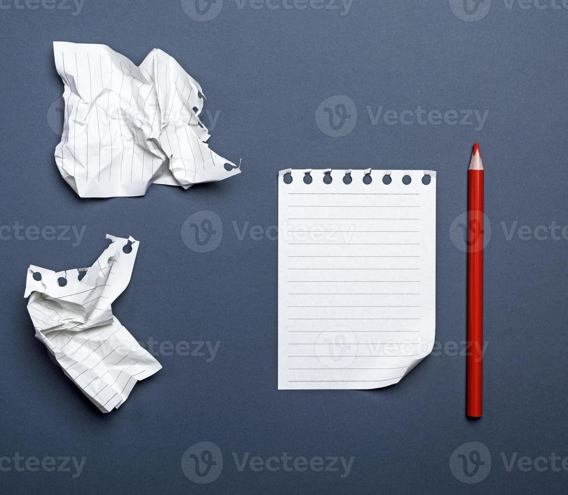 white blank sheets in a line from a notepad and red wooden pencil photo