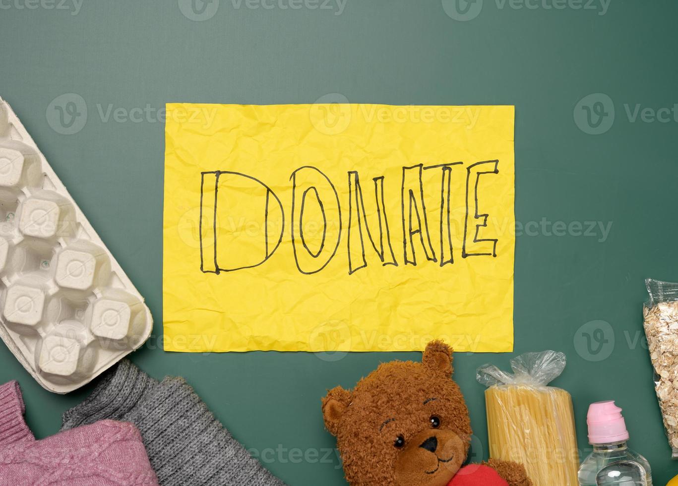clothes and brown teddy bear on a green background, top view photo