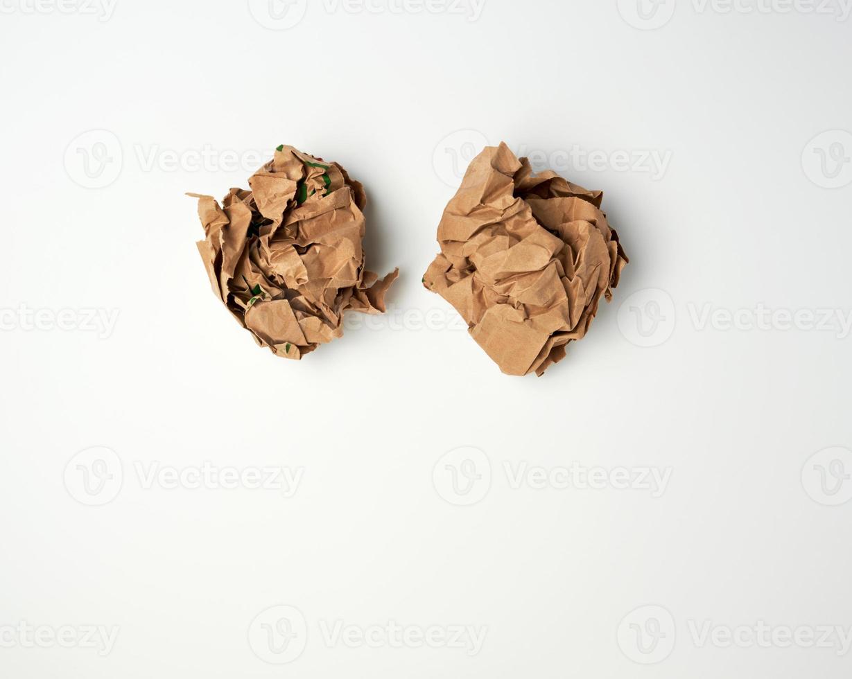 two crumpled sheets  of brown paper on a white background photo
