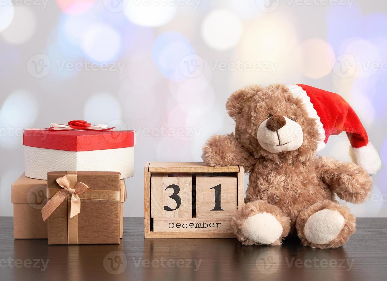 brown teddy bear and a stack of various cardboard boxes for gifts on a black table photo
