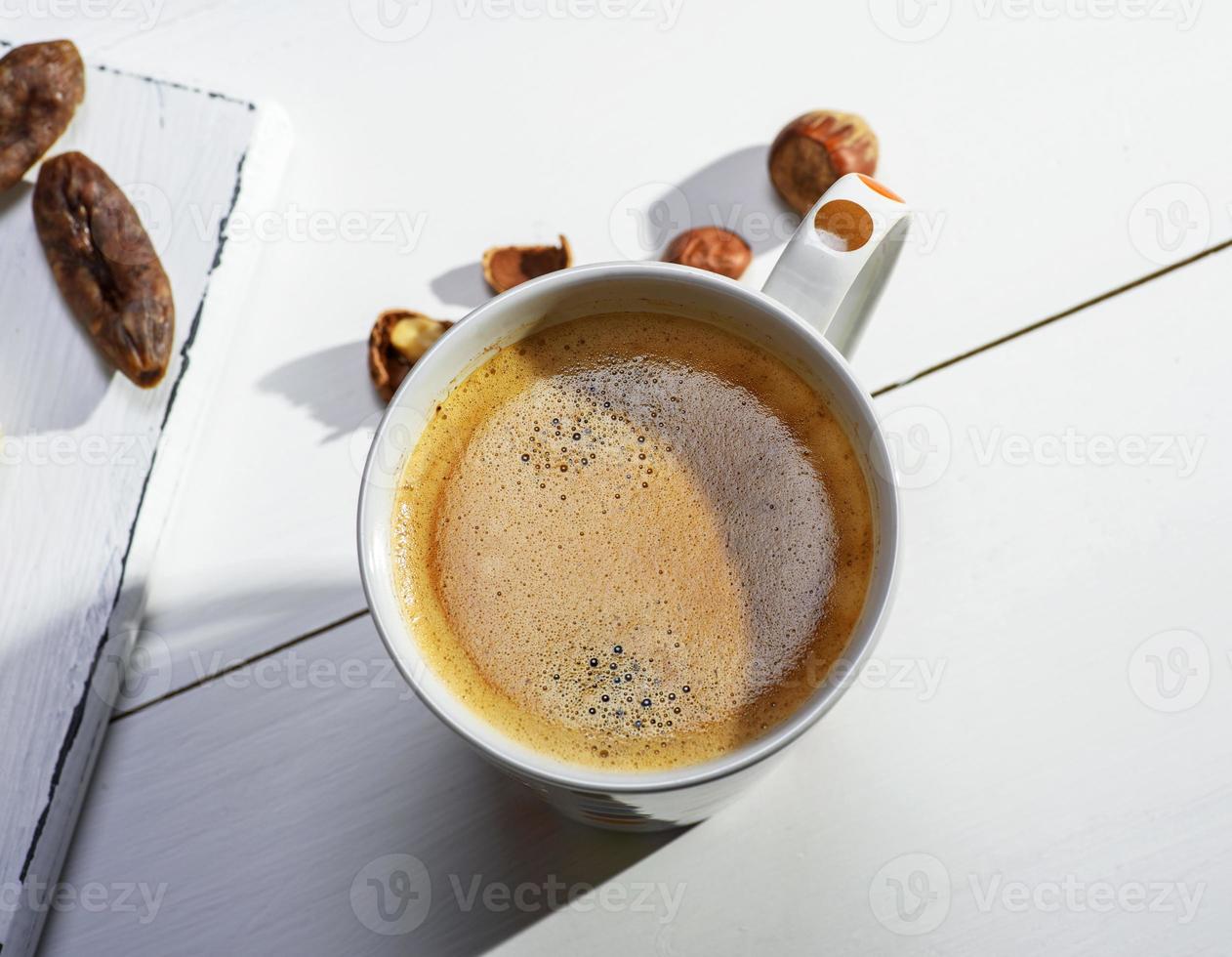 white ceramic mug with black coffee and foam photo