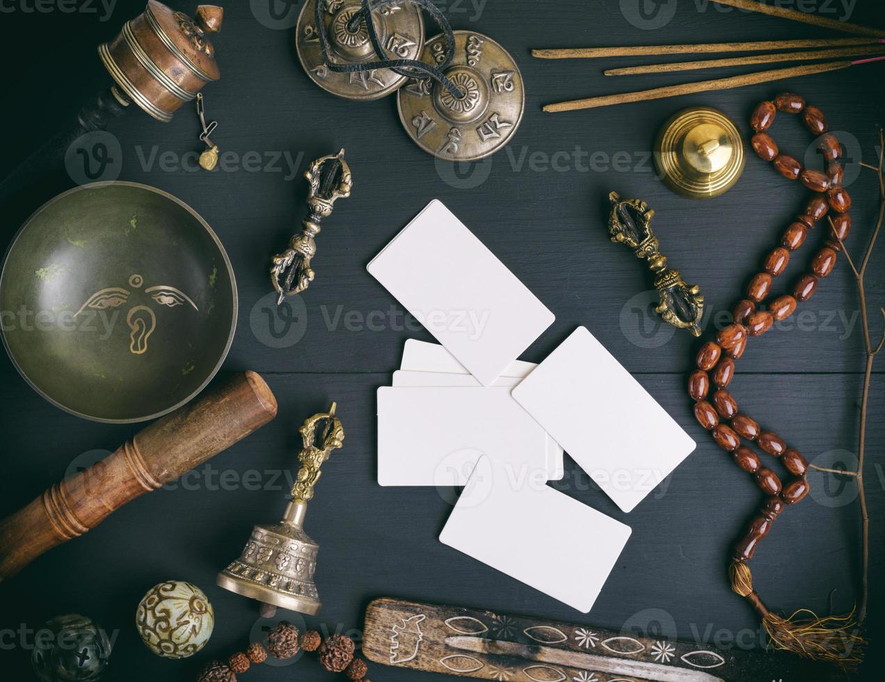 tarjetas de visita blancas vacías en medio de objetos religiosos asiáticos para la meditación y la medicina alternativa foto