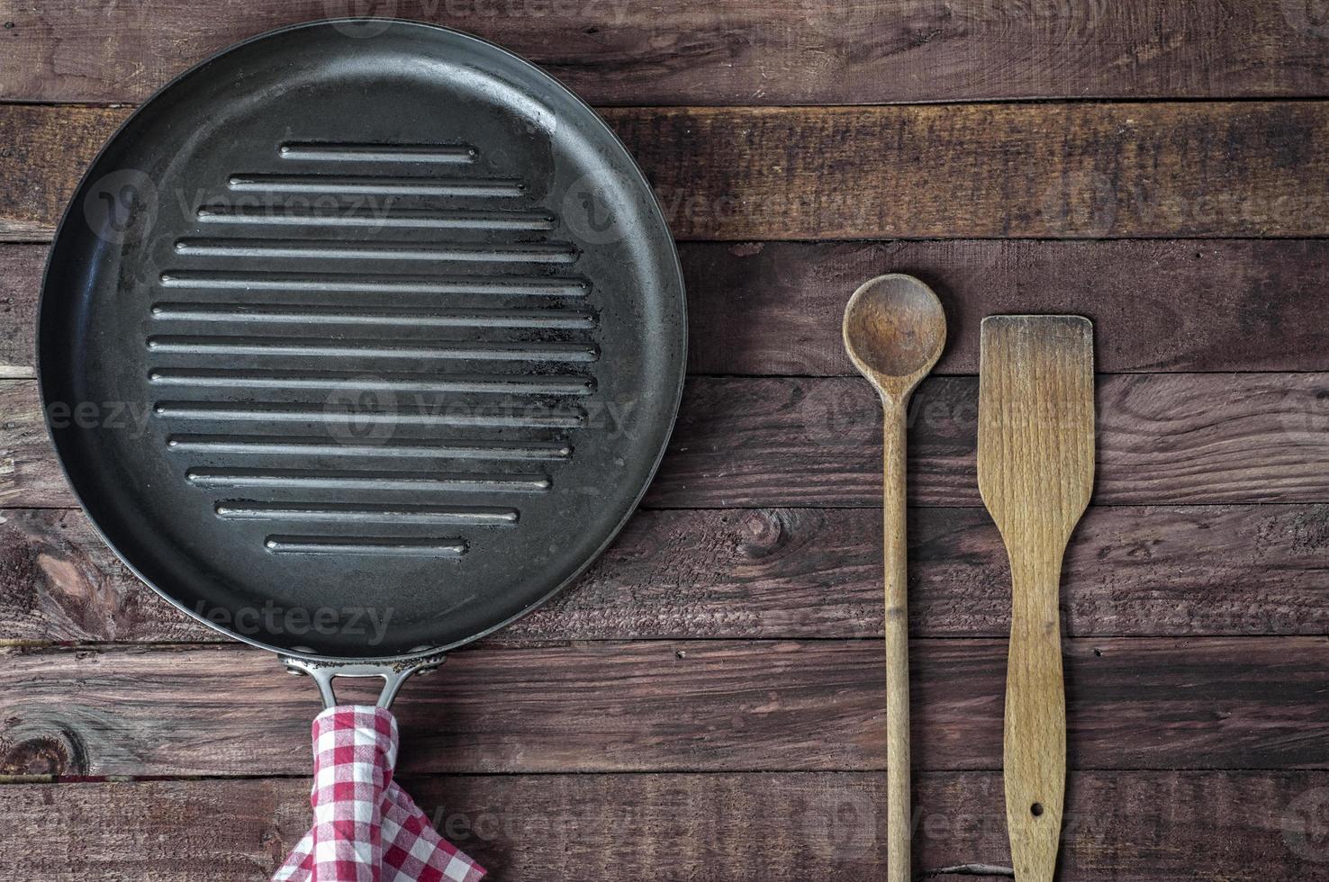 Empty grill pan and wooden cooking utensils photo