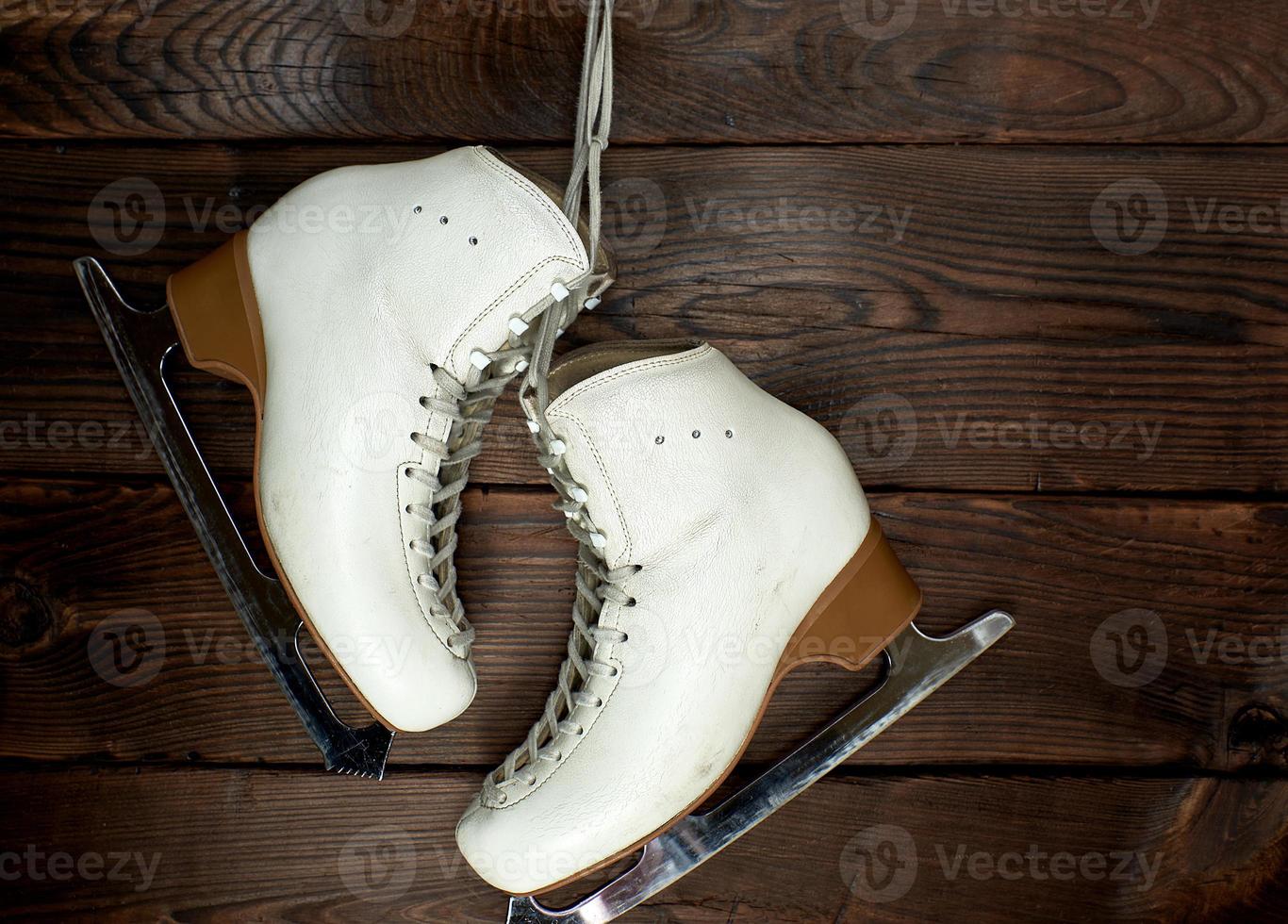 white leather womens skates for figure skating hang on a nail photo