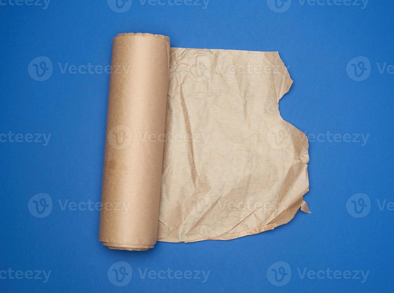 roll of brown parchment paper on a blue background, copy space photo