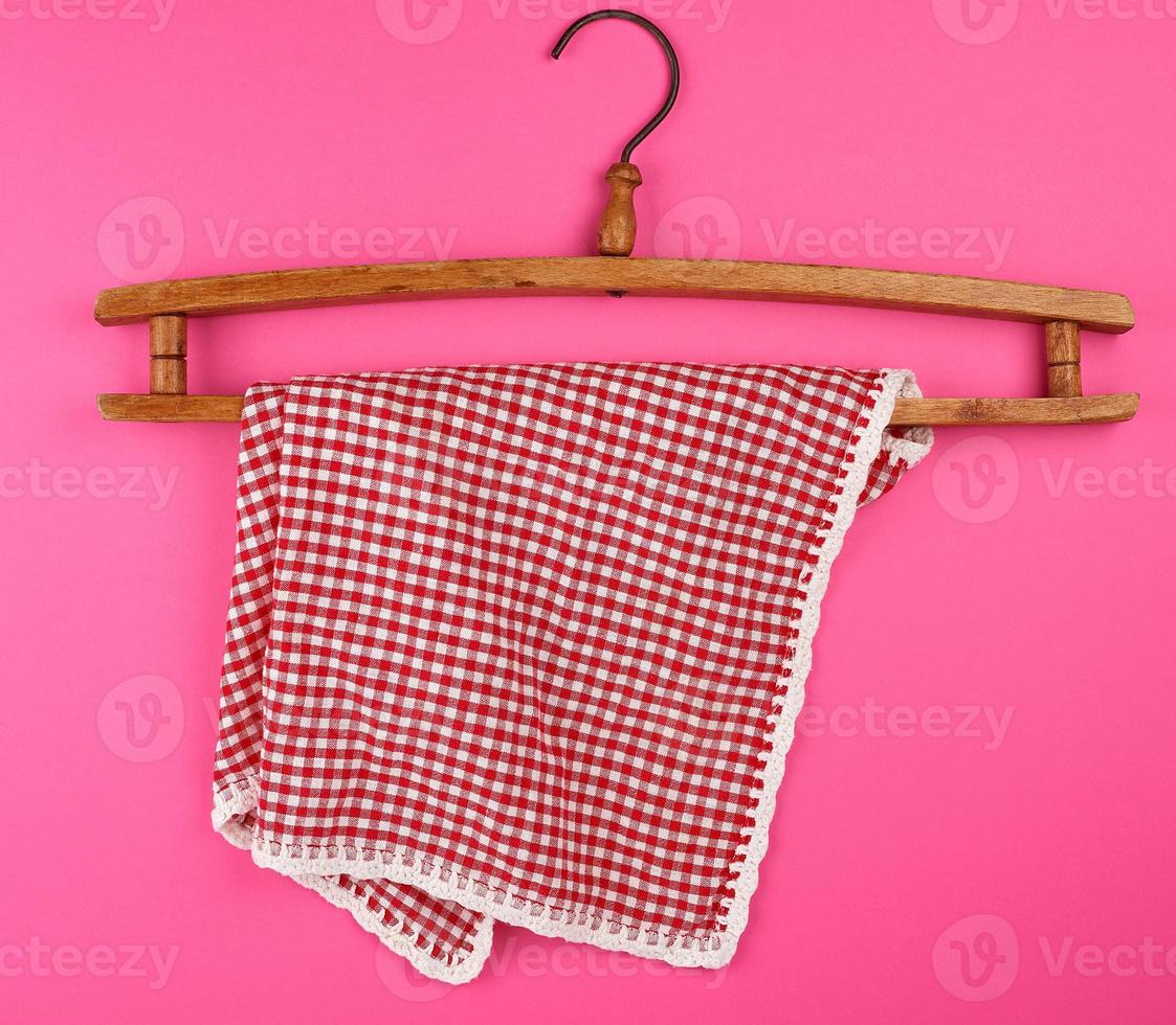 red checkered kitchen towel hanging on a vintage wooden hanger photo