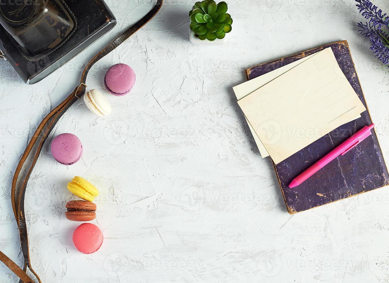 baked round macarons, notebook, pen and plants in a pot photo