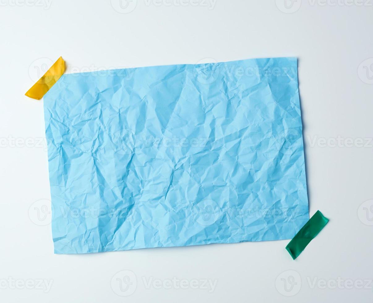 blue crumpled sheet of paper glued with adhesive tape photo