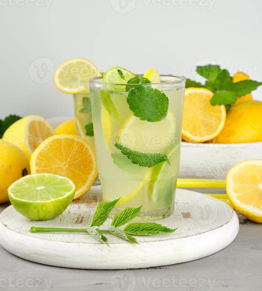 refreshing drink lemonade with lemons, mint leaves, lime in a glass photo
