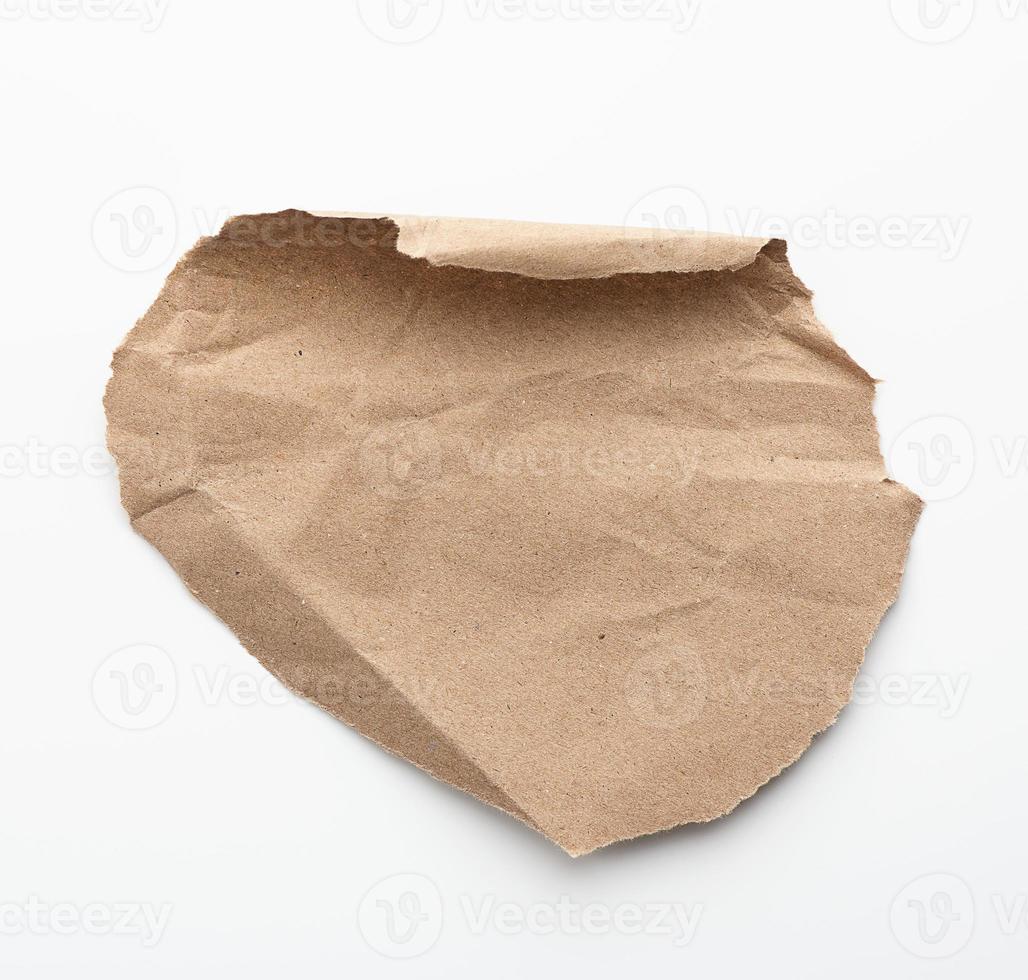 round piece of brown paper paper with torn edges on a white background photo
