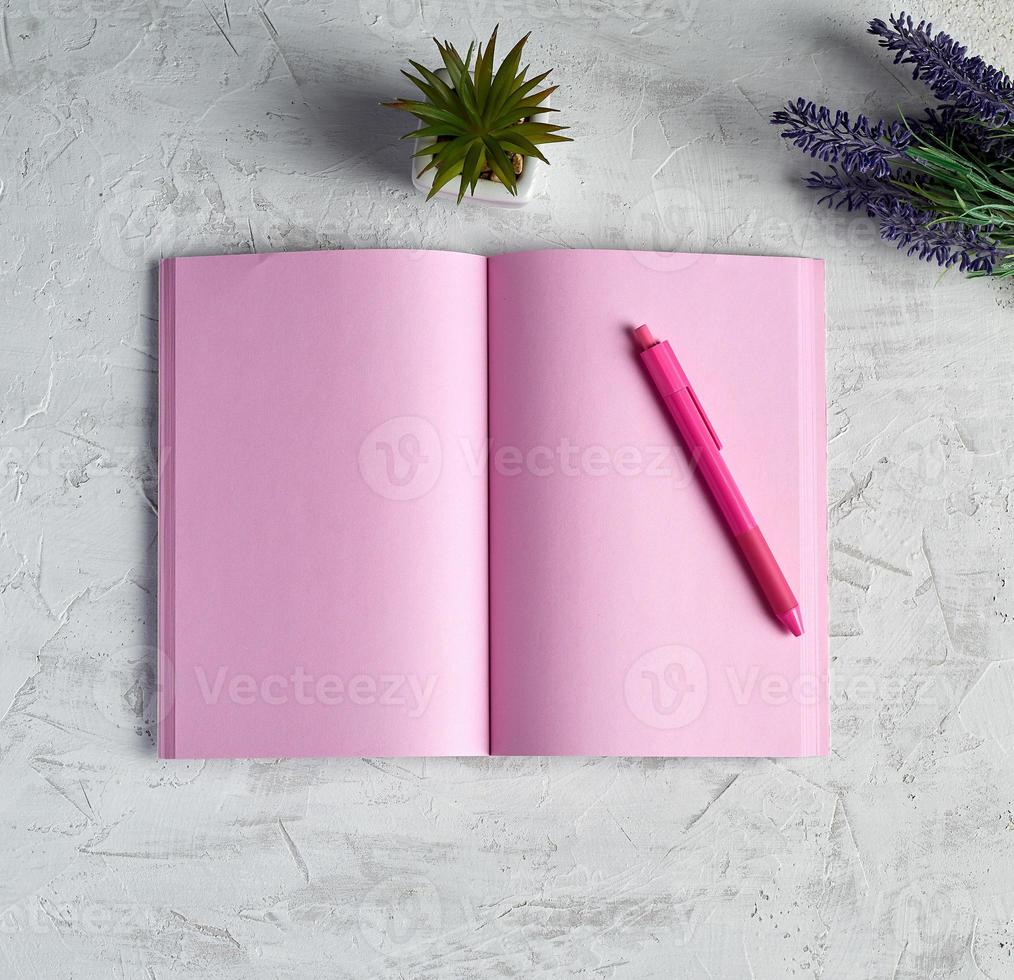 cuaderno abierto con páginas rosas en blanco, lápiz rojo y un ramo de lavandas foto