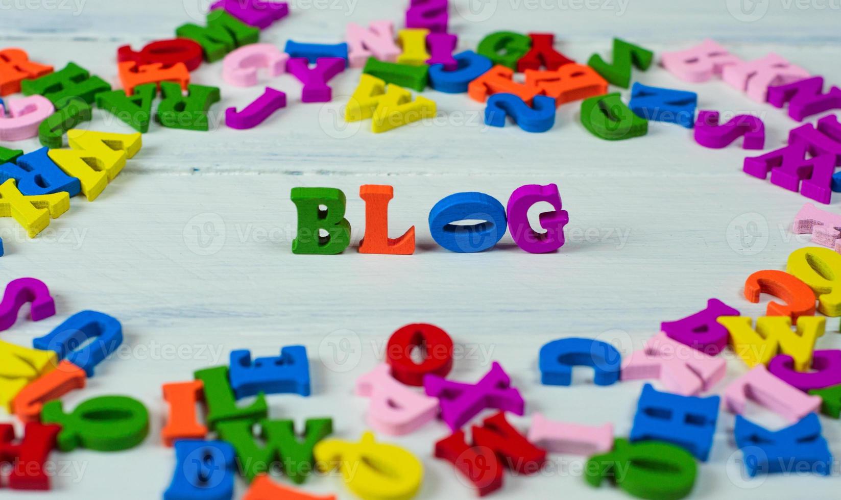 Wooden colorful letters of the English alphabet on a white wooden surface photo