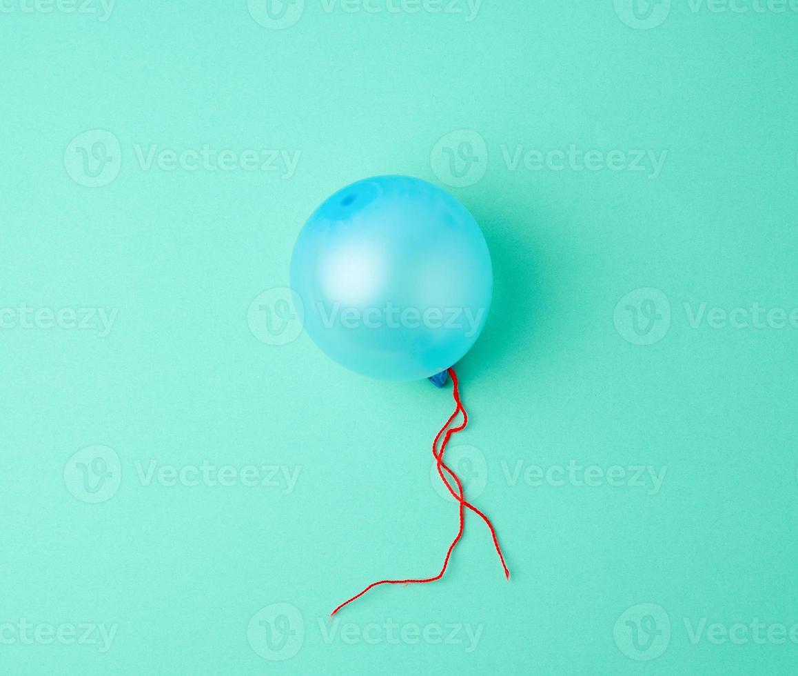 inflated blue rubber balloon on a green background photo