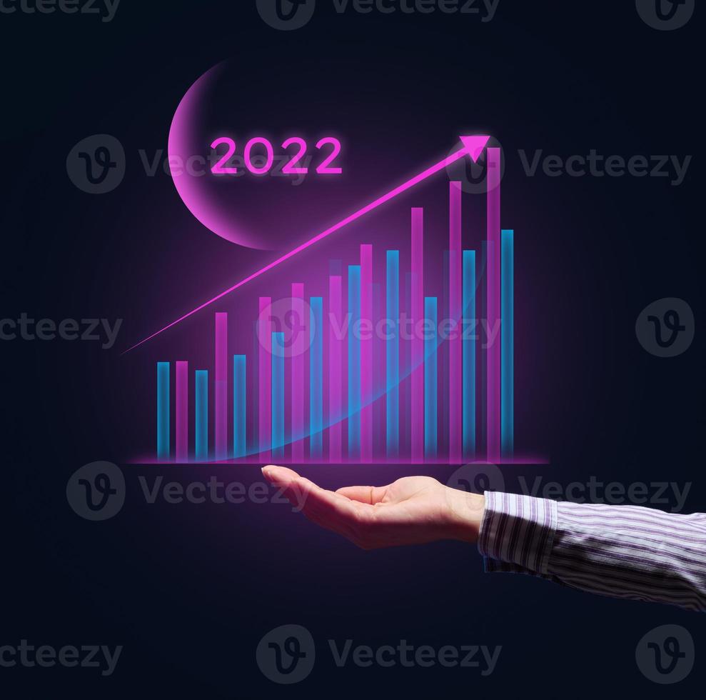 Holographic graph with growing indicators and a businessman's hand. The concept of business growth in the new year, the beginning of success photo