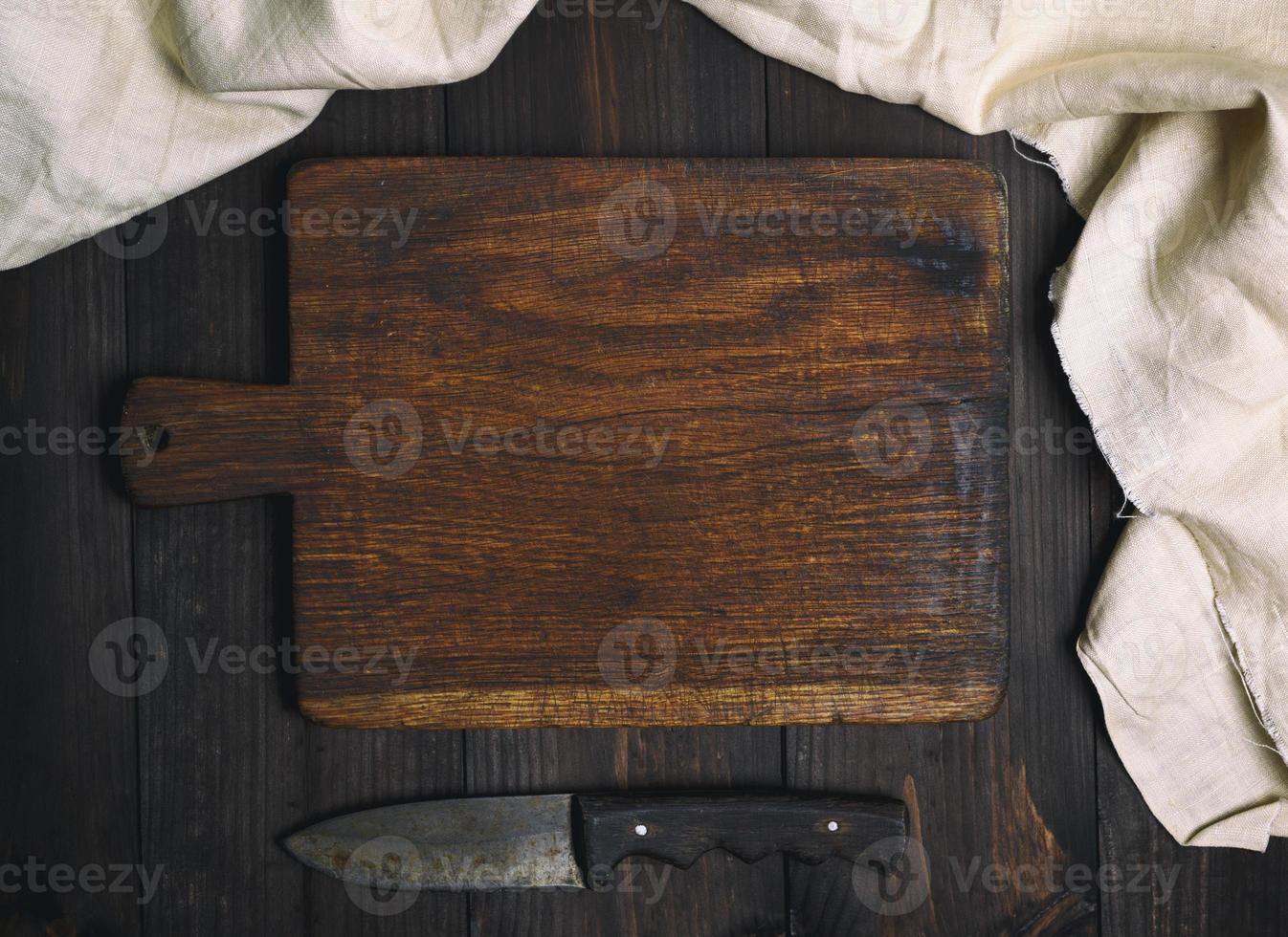 tabla de cortar de madera marrón vieja vacía con mango foto
