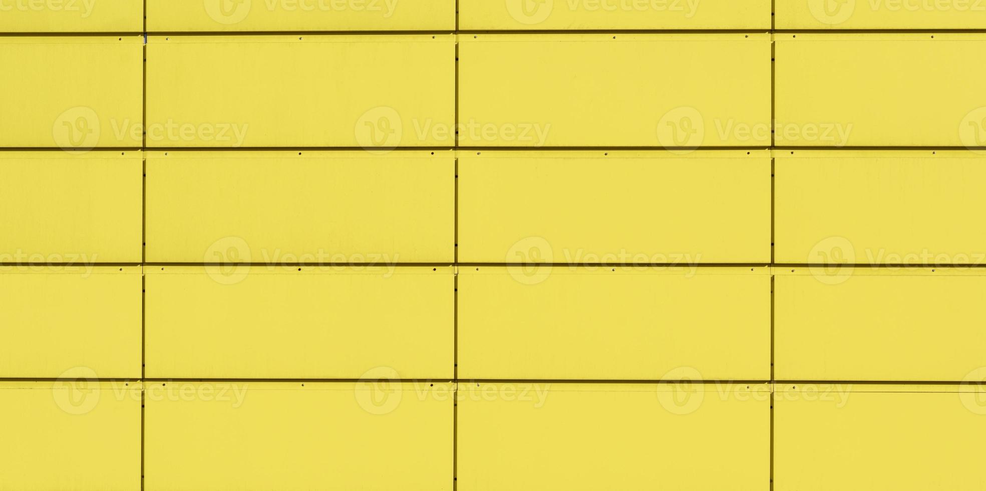 fragment of a yellow iron wall made of rectangular blocks photo