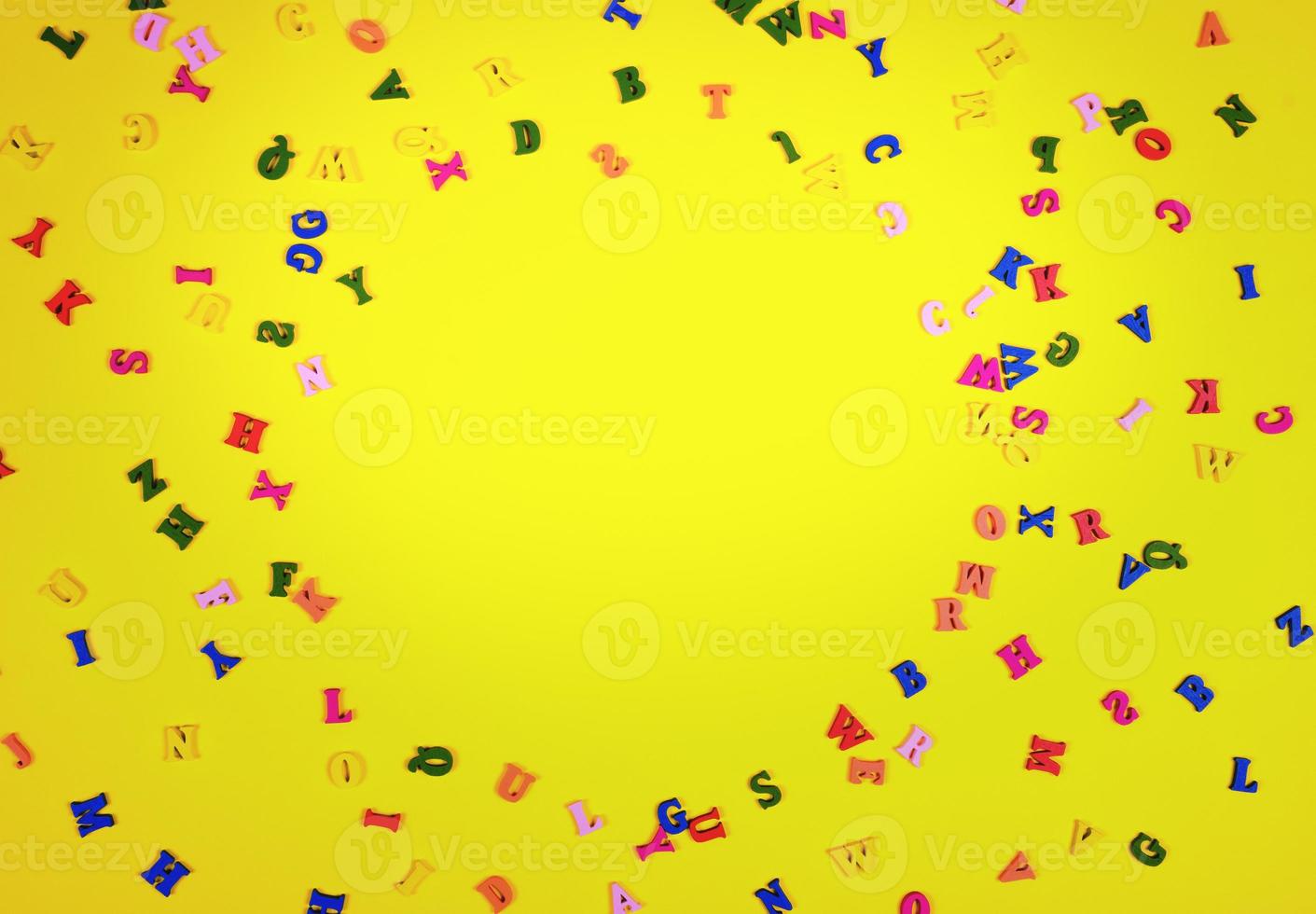 Multicolored wooden letters on a yellow surface photo