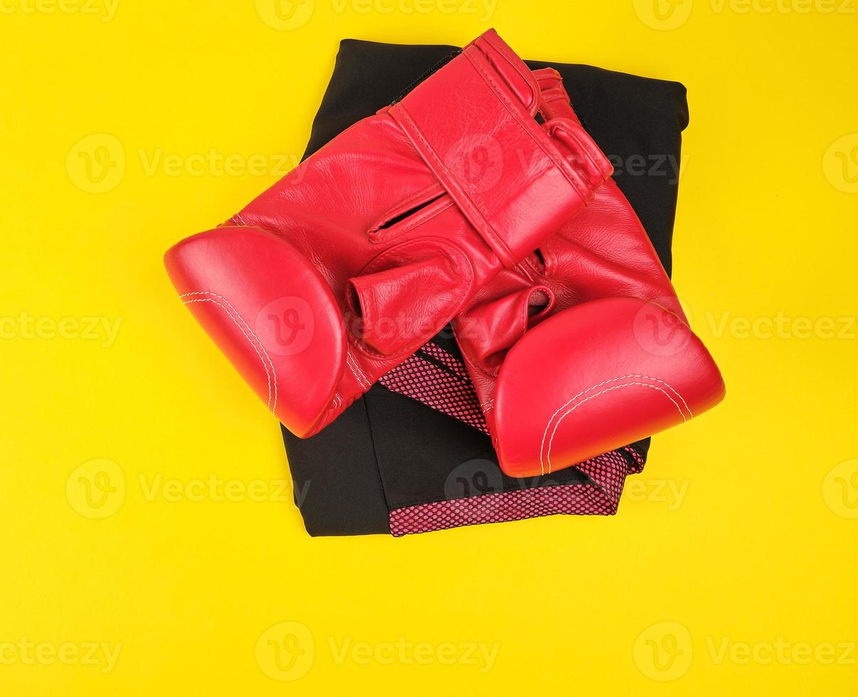 pair of red leather boxing gloves on a yellow  background photo