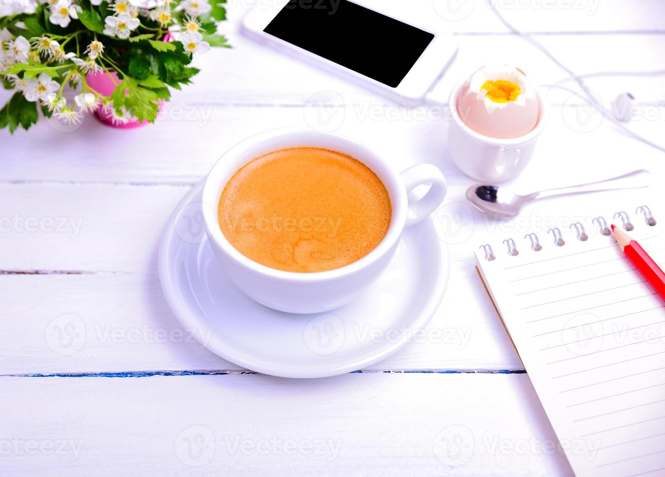 taza de café y cuaderno con un lápiz rojo foto