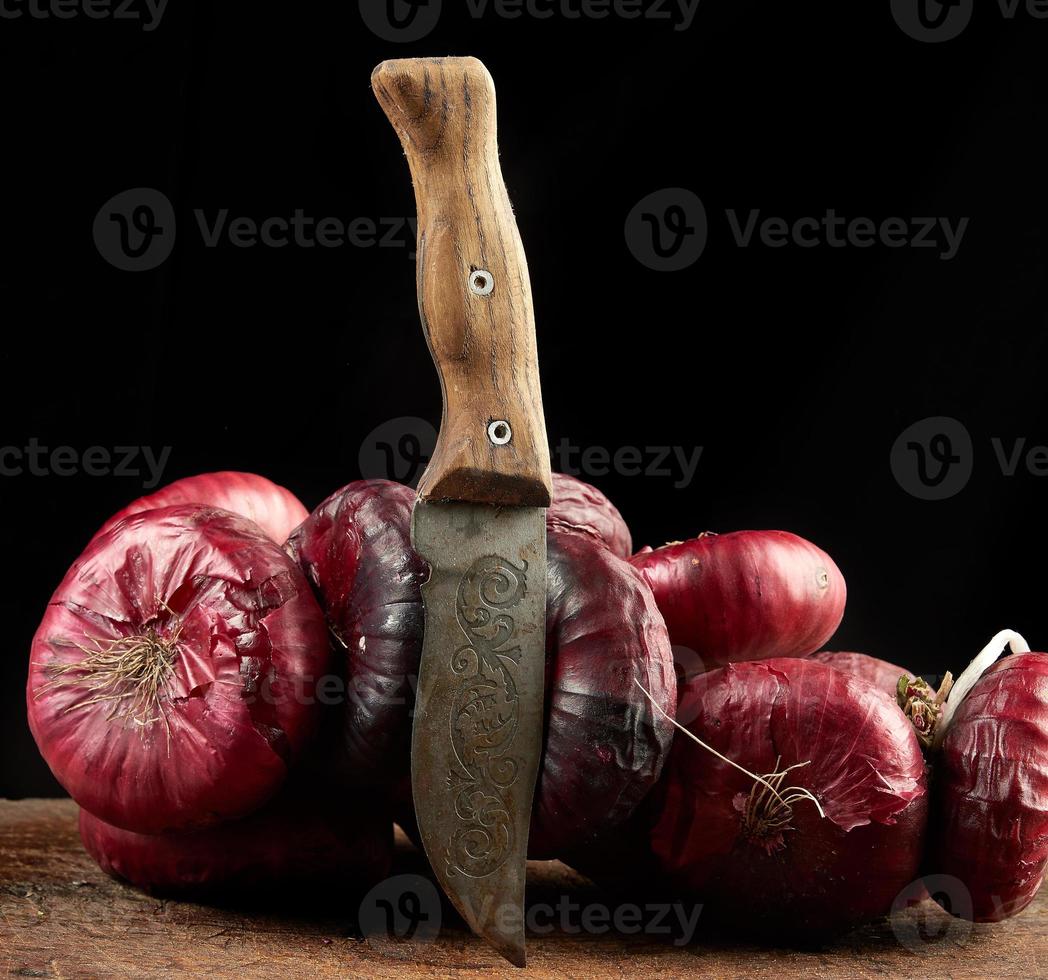round red onion in husk on a gray linen napkin, black background photo