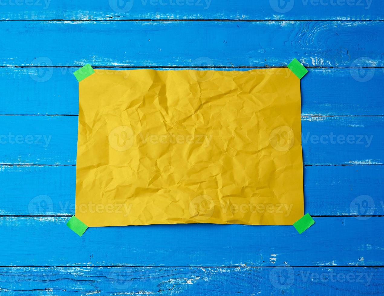 empty yellow crumpled sheet of paper glued with green sticky pieces of paper photo