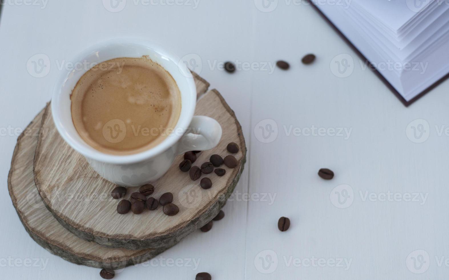 White cup of coffee on the white wooden background photo