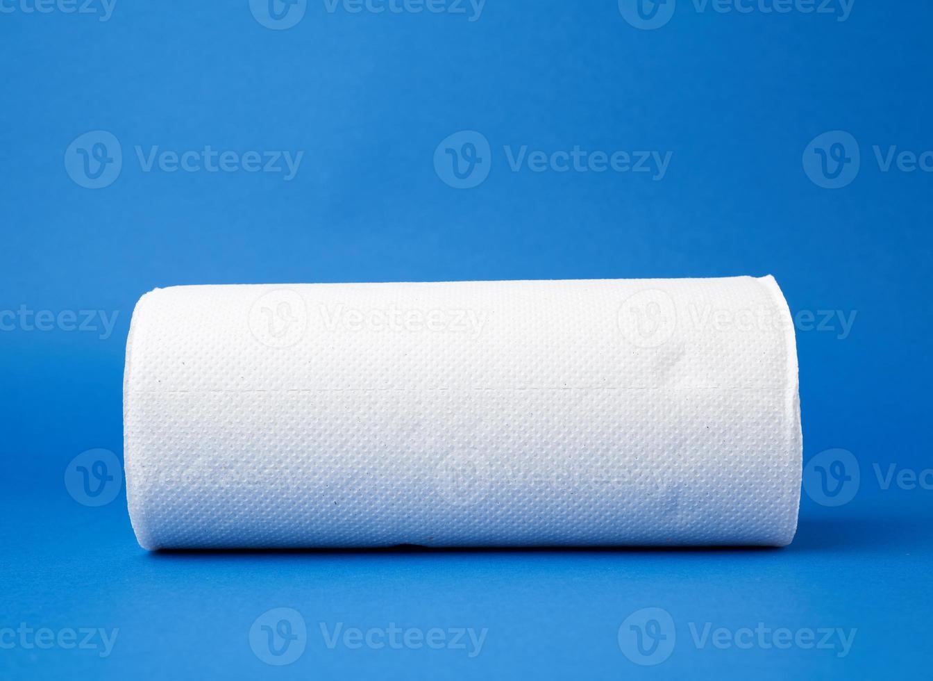 twisted roll of white paper towel on a blue background photo